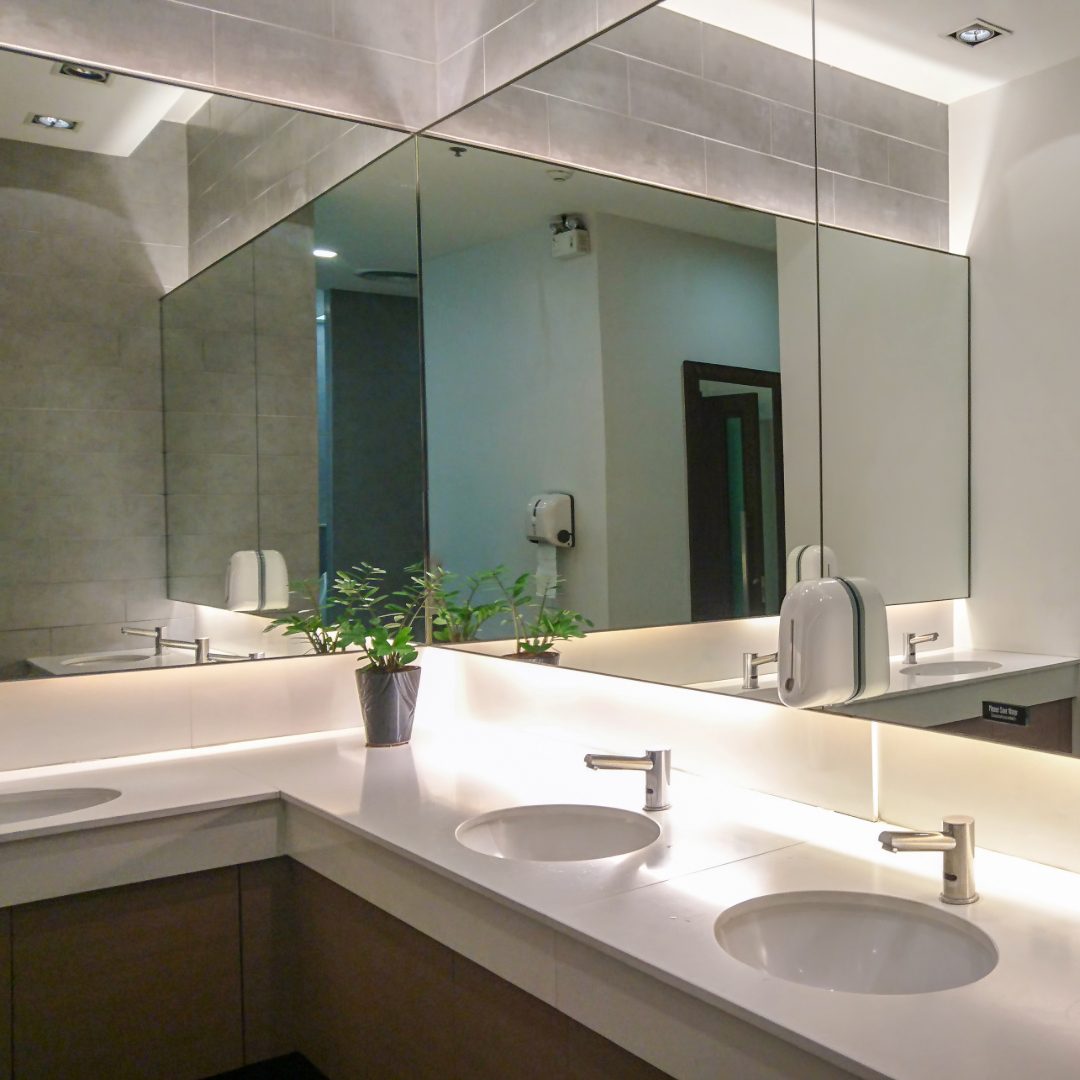 Full-width mirror wall in a commercial washroom